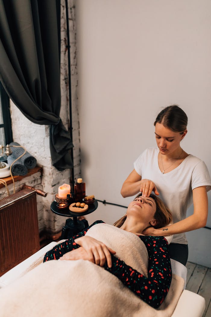 portfolio-05 Woman receiving calming facial massage in serene indoor spa setting.